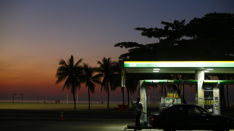 Un trabajador se prepara para cargar el depósito de un vehículo enun estación de servicio en la playa de Copacabana, en Rio de Janeiro (Brasil). REUTERS/Ricardo Moraes