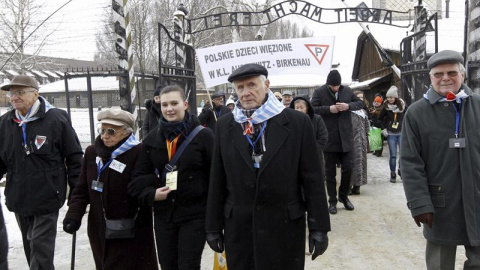 El exprisionero Wieslawa Borysewicz (c) y otros antiguos internos entran en el campo de concentración nazi de Auschwitz. EFE