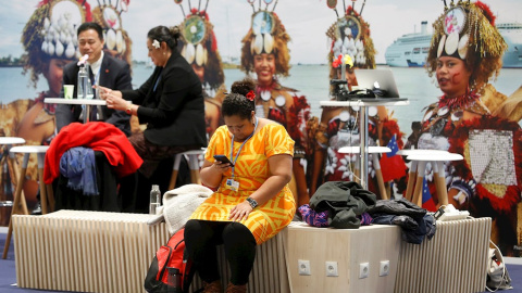 Una mujer observa su móvil en uno de los stands de la 25 Conferencia de las Partes del Convenio Marco de Naciones Unidas sobre Cambio Climático (COP), en Madrid. EFE/Chema Moya