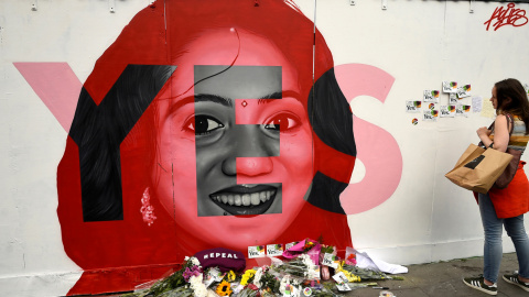 Una mujer observa un mural de Savita Halappanavar con ofrendas de flores en Dublín el día del referéndum en Irlanda sobre la liberalización del aborto. REUTERS/Clodagh Kilcoyne