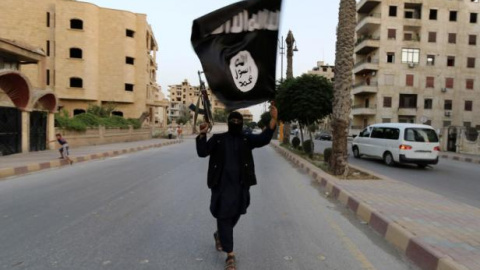 Militante del Estado Islámico agita la bandera negra de su organización. Foto: Reuters