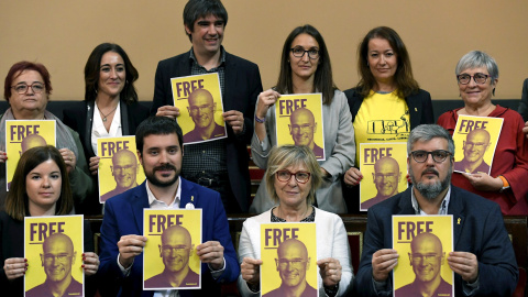 03/12/2019.- Los senadores de EH Bildu y Esquerra Republicana muestran un cartel del exconsejero de la Generalitat en prisión Raül Romeva durante la sesión constitutiva de la Cámara Alta. EFE/Victor Lerena