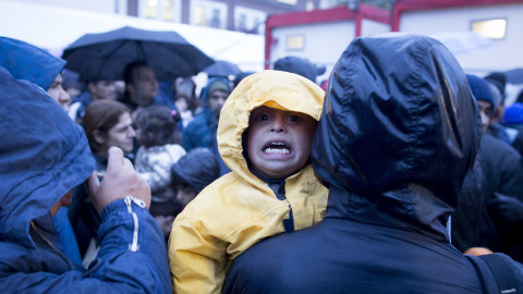 Un niño llora mientras cientos de refugiados esperan con frío a las puertas de la Oficina de Sanidad y Asuntos Sociales en Berlín. EFE/Kay Nietfeld