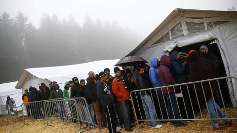 Varios refugiados hacen cla para comer en el refugio temporal de Schwarzenborn (Alemania). REUTERS/Kai Pfaffenbach