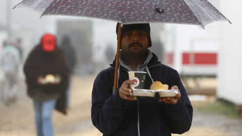 Un refugiado con su comida en el refugio temporal de Schwarzenborn (Alemania). REUTERS/Kai Pfaffenbach