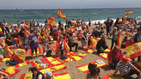 Grup d'unionistes estenen banderes espanyoles a la platja de Barcelona