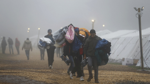 Varios refugiados trasladan sus pertenencias al abandonar un refugio temporal con temperaturas que rozan los cero grados cerca de Schwarzenborn (Alemania). REUTERS/Kai Pfaffenbach