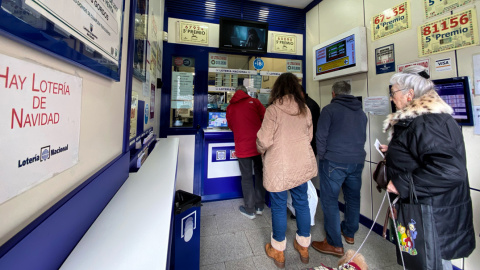 Varias personas compran décimos de Lotería de Navidad en una Administración del centro de Madrid. E.P./Eduardo Parra