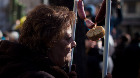 Una mujer protesta contra la corrupción portando un chorizo durante la Marcha del Cambio, convocada por Podemos en Madrid. -JAIRO VARGAS