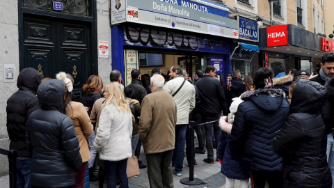 08/12/2019.- Decenas de personas hacen cola  en la administración de Loterías Doña Manolita, en Madrid, para comprar la tradicional lotería de Navidad. / EFE - BALLESTEROS