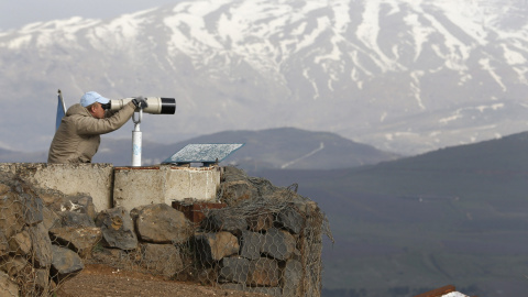 Un miembro de UNDOF observa con unos binoculares el monte Bental, en el Golan. REUTERS