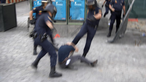 Tres agentes de la Policía Nacional golpean a un manifestante.- AMNISTÍA INTERNACIONAL