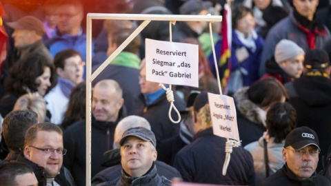 Simpatizantes de PEGIDA muestran una horca con mensajes amenazantes hacia Merkel. / REUTERS