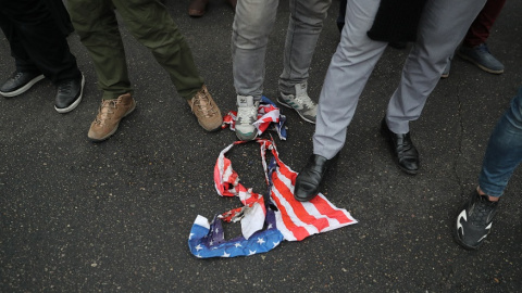 Manifestantes iranís pisan una bandera estadounidense en Teherán. EUROPA PRESS