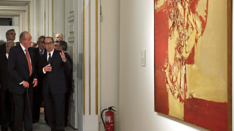 El rey Juan Carlos escucha las explicaciones del pintor, escultor y grabador Rafael Canogar, durante la inauguración de la exposición 'Arte Contemporáneo en Palacio: Pintura y Escultura en las Colecciones Reales'. EFE/J. J. Guillén