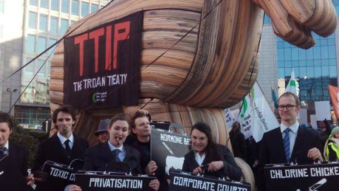 El caballo de Troya colocado frente a la sede de la Comisión Europea en Bruselas, en la protesta contra el Tratado de Libre Comercio, con algunos activistas de la organización Friends of the Earth.