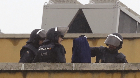 Efectivos de la Policía Nacional permanecen en la azotea del Centro de Internamiento de Extranjeros (CIE) de Aluche, en Madrid, donde anoche se encerraron unos cuarenta inmigrantes. EFE/Paco Campos