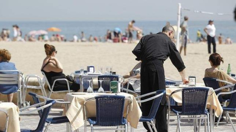 Un camarero atiende a una pareja en una terraza este verano. /EFE