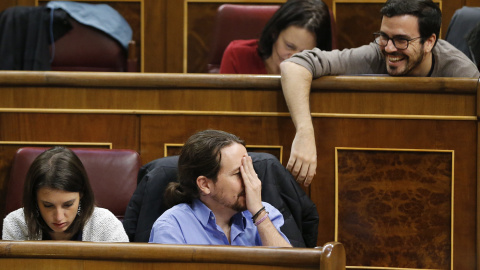 El coordinador federal de Izquierda Unida, Alberto Garzón, conversa con el líder de Podemos, Pablo Iglesias, durante el pleno del Congreso. EFE/Mariscal