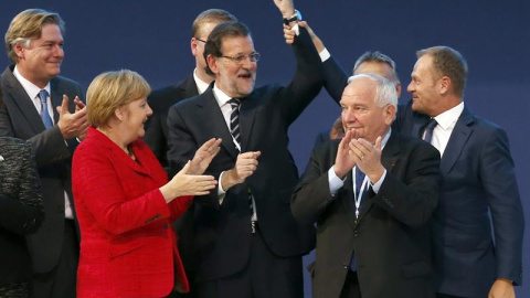 El presidente del Consejo Europeo, Donald Tusk (d), levanta el brazo del presidente del Gobierno, Mariano Rajoy (c), junto al presidente el PPE, Joseph Daul (2d), y la canciller alemana, Angela Merkel (2i), mientras posan para la foto de fa