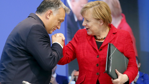 Viktor Orban besa la mano de la canciller Angela Merkel antes de su intervención en el Congreso del Partido Popular Europeo. - REUTERS