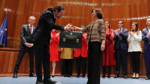 El líder de Podemos y nuevo vicepresidente de Derechos Sociales, Pablo Iglesias, hace una pequeña reverencia al recibir la cartera de manos de la vicepresidenta Carmen Calvo, en el acto de toma de posesión. REUTERS/Susana Vera