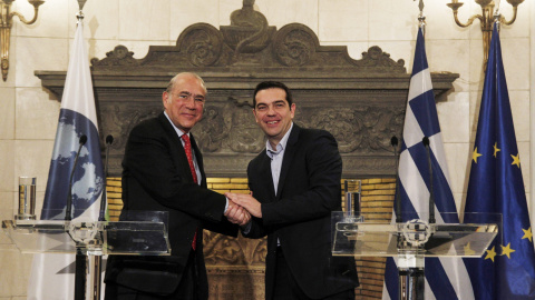 El primer ministro griego, Alexis Tsipras, estrecha la mano al secretario general de la OCDE, José Ángel Gurría, durante una rueda de prensa conjunta tras mantener un encuentro en Atenas. EFE/Alexandros Vlachos