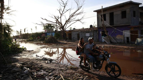 Una familia transita en una motocicleta hoy, sábado 24 de octubre de 2015, tras el paso del huracán Patricia en una calle de la comunidad de Emiliano Zapata (México)