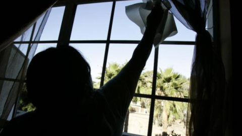 Una mujer limpia unos cristales de una casa. REUTERS/Archivo.