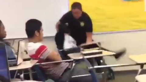 Captura del vídeo que muestra al policía reduciendo con violencia a una estudiante en actitud pacífica.