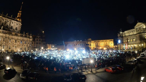 Seguidores del movimiento islamófobo Pegida encienden las linternas de sus teléfonos celulares durante una manifestación en la plaza Theaterplatz de Dresde (Alemania)./ EFE