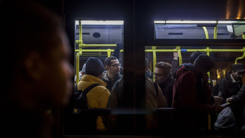 Un grupo de solicitantes de asilo, en el autobús que va hacia el albergue para personas sin hogar del Ayuntamiento de Madrid, tras más de una semana sin obtener plaza.- JAIRO VARGAS