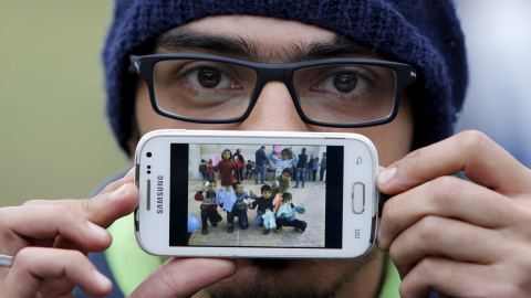 Basas es un refugiado sirio, natural de Damasco, la capital Siria. En la imagen de su teléfono, muestra a los niños de la escuela en la que trabajaba como voluntario. Ahora espera para cruzar la frontera entre Eslovenia y Austria en Sentilj