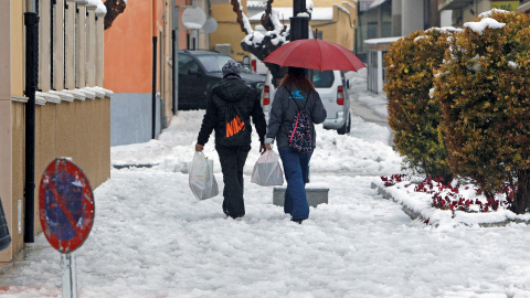 20/01/2020.- Dos pesonas caminan por una calle de la localidad alicantina de Castalla que amanecía hoy cubierta de nieve por el temporal Gloria que afecta a gran parte de la península. EFE/Morell