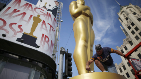 El decorador Rick Roberts pinta de dorado una de las estatuas del Oscar, junto al Dolby Theater donde se celebrará la ceremonia de entrega de los 87ª premios de la Academia de Hollywod. REUTERS/Lucy Nicholson