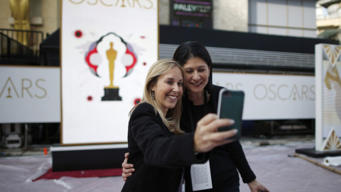 Dos mujeres se hacen un selfie junto a uno de los carteles anunciadores de la 87ª gala de entrega de los premios Oscan en  el Dolby Theater de Los Ángeles. REUTERS/Lucy Nicholson