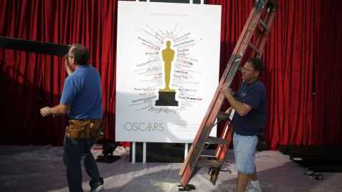 Unos trabajadores pasan junto al poster que anuncia la ceremonia de entrega de los 87ª premios Oscar, en el Dolby Theater de Los Angeles. REUTERS/Lucy Nicholson