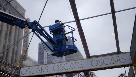 Un trabajador coloca un toldo para proteger de la lluvia la alfombra roja por donde desfilarán los asistentes a la 87ª cereonia de enmtrega de los premios Oscar. REUTERS/Rick Wilking