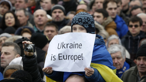 Un niño, sobre los hombros de un adulto, sostiene una pancarta en la que se lee 'Ucrania en Europa', durante la llamada Marcha de la Dignidad, para celebrar el aniversario del levantamiento de la plaza de Maidan, en Kiev. REUTERS/Valentyn O