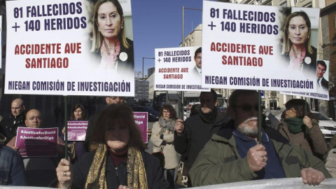 Varios miembros de la plataforma "Víctimas Alvia 04155" durante la concentración frente a la plaza de Neptuno, una hora antes de que comenzara el debate sobre el estado de la nación, con carteles de protesta: "verdad y justicia". EFE/Paco C