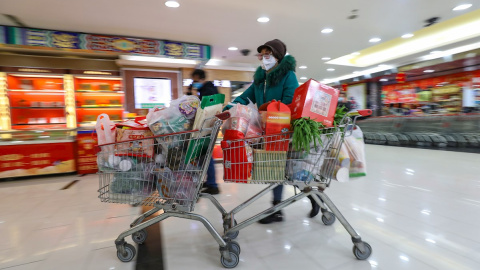 Una mujer con máscara compra en un supermercado en Wuhan. EFE