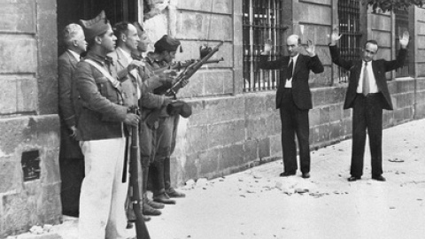 Soldados favorables a Franco encañonan a dos transeúntes, en una calle de Sevilla, al inicio de la Guerra Civil. / EFE