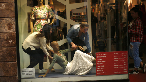 Dos empleadas de una tienda en el centro de Madrid arreglan en el escaparate. REUTERS