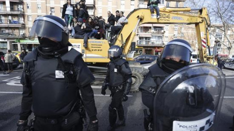 Agentes de Policía Municipal ante las personas subidas en una excavadora que trataban de evitar el desalojo de la vivienda en el número 29 de la calle Ofelia Nieto./ EFE-Javier Lizón