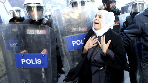 Una mujer kurda se encara con policías antidisturbios turcos durante una protesta contra la detención de doce diputados del Partido Democrático de los Pueblos (HDP). / EFE