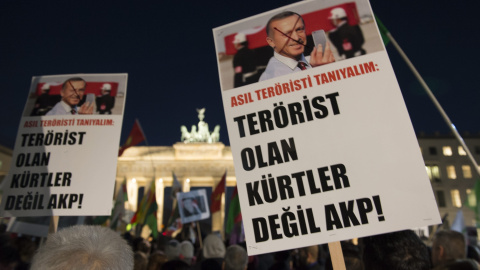 Manifestantes muestran pancartas en las que se lee "Actualmente deberíamos conocer a los terroristas. No son los kurdos, pero del AKP" durante una protesta frente a la Puerta de Brandenburgo, Berlín (Alemania). / EFE