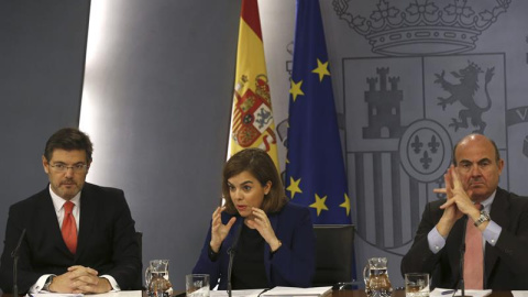 La vicepresidenta del Gobierno, Soraya Sáenz de Santamaría, y los ministros de Justicia Rafael Catalá (izq.) y de Economía Luis de Guindos durante la rueda de prensa del Consejo de Ministros. EFE/SERGIO BARRENECHEA