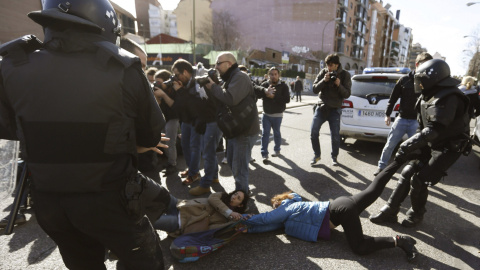 Agentes de Policía Municipal tratan de mover a varias de las personas que trataban de evitar el desalojo de la vivienda en el número 29 de la calle Ofelia Nieto./EFE-Javier Lizón