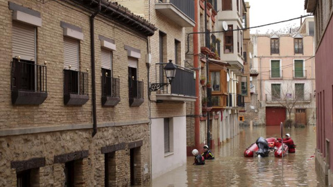 Voluntarios de Cruz Roja recorren las calles anegadas por el agua del casco histórico de Tudela (Navarra) para atender a los vecinos que han quedado incomunicados por la crecida del río Ebro, que se ha desbordado tras las intensas precipita