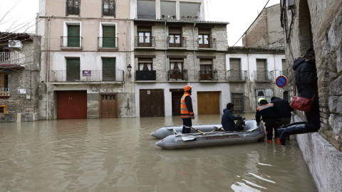 Miembros de Proteccion Civil ayudan a varias personas en el Casco Viejo de Tudela, coincidiendo con la máxima crecida del Rio Ebro, donde se han inundado las calles de la ciudad. /Jesús Diges (EFE)